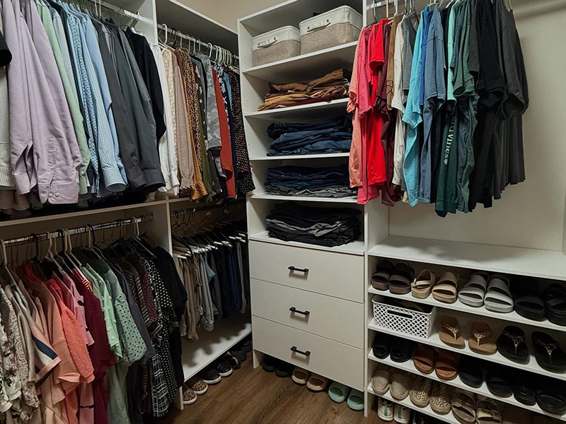 Detailed view of walk-in closet organization features including hanging systems and drawer storage
