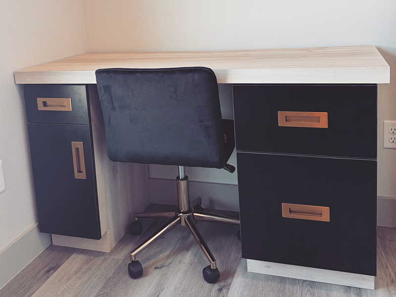 Detailed view of home office cabinet design features including integrated desk, filing systems, and cable management
